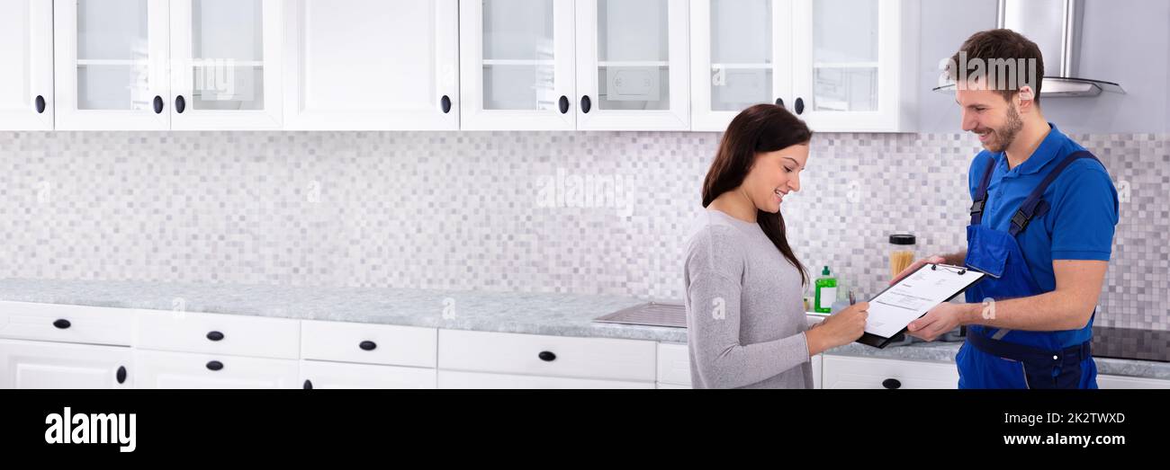 Frau Unterzeichnung Rechnung in der Küche Stockfoto