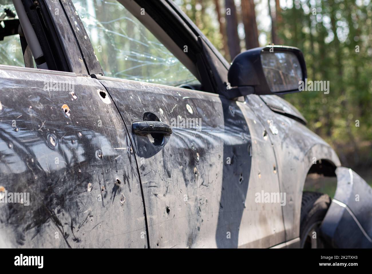 Ein Auto voller Zivilisten, von den Invasoren während des Krieges in der Ukraine erschossen. Verkehrsunfall oder Zwischenfall, Autounfall. Splitterlöcher in der Karosserie des Autos. Gräueltaten der russischen Armee. Stockfoto