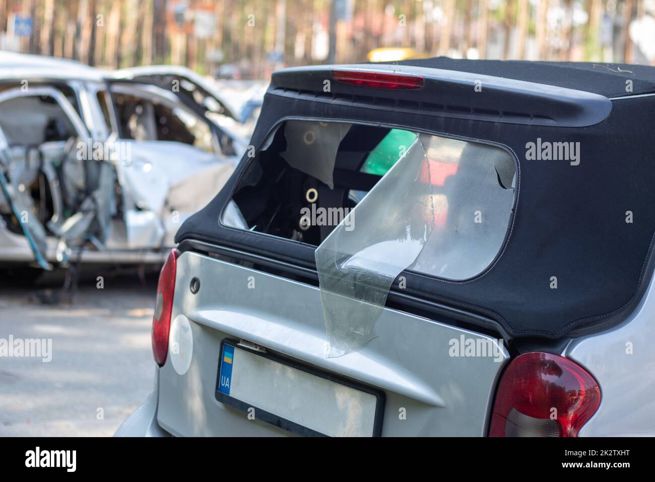 Viele kaputte Autos nach einem Verkehrsunfall auf dem Parkplatz einer Tankstelle auf der Straße. Werkstatt für Karosserieschäden im Freien. Verkauf von Versicherungs-Einsatzfahrzeugen auf Auktion. Stockfoto