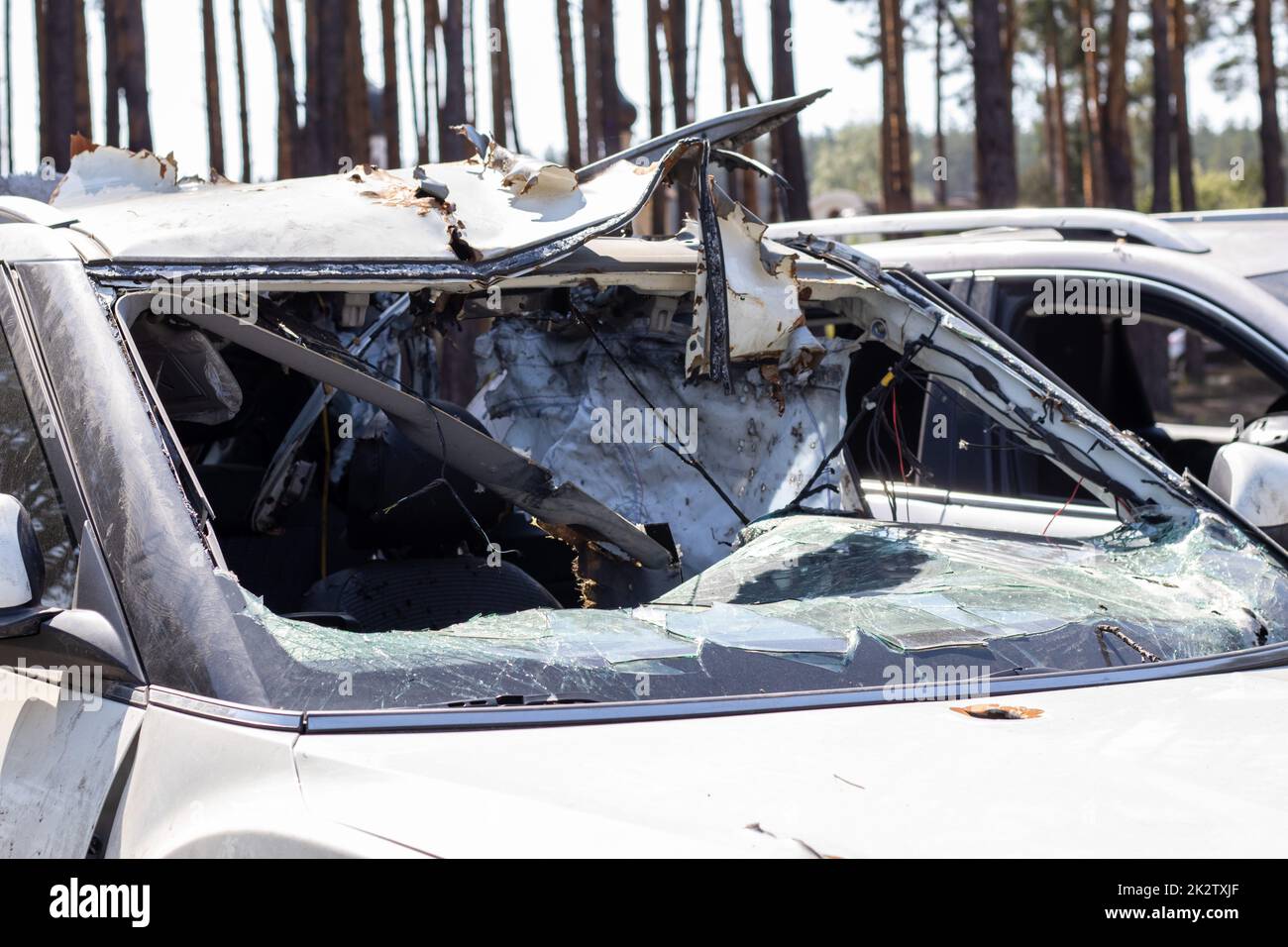 Hat während des Krieges in der Ukraine ein Auto erschossen. Ein Auto voller Zivilisten mit Splitterlöchern von Explosionen. Autounfall. Autofriedhof. Spuren von Schüssen am Körper. Das Fahrzeug wurde nach dem Beschuss beschädigt. Stockfoto