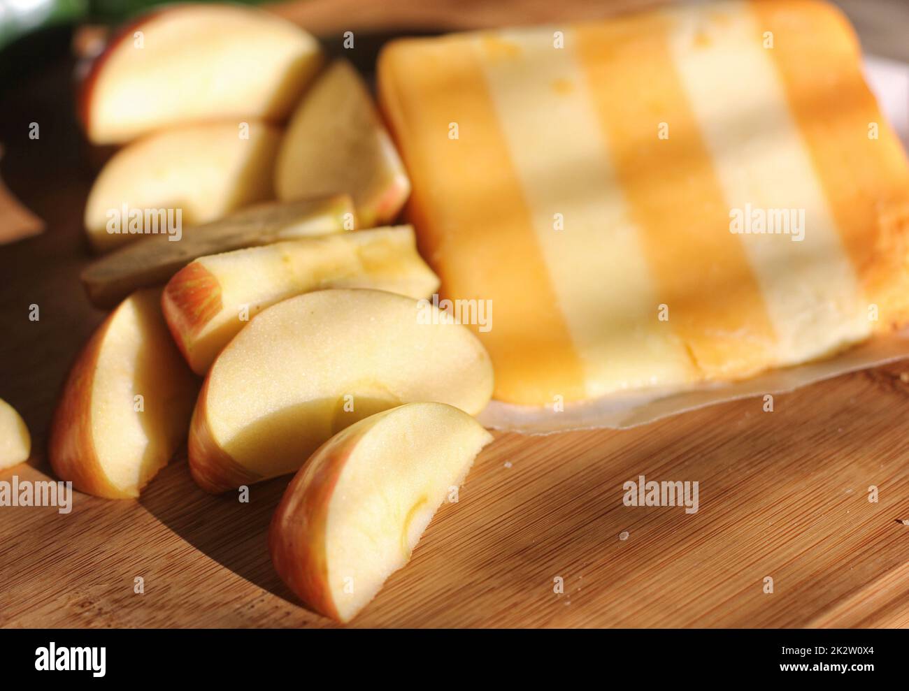 5 geschichteter englischer Käse mit Äpfeln in rustikaler Küche mit natürlichem Licht Stockfoto