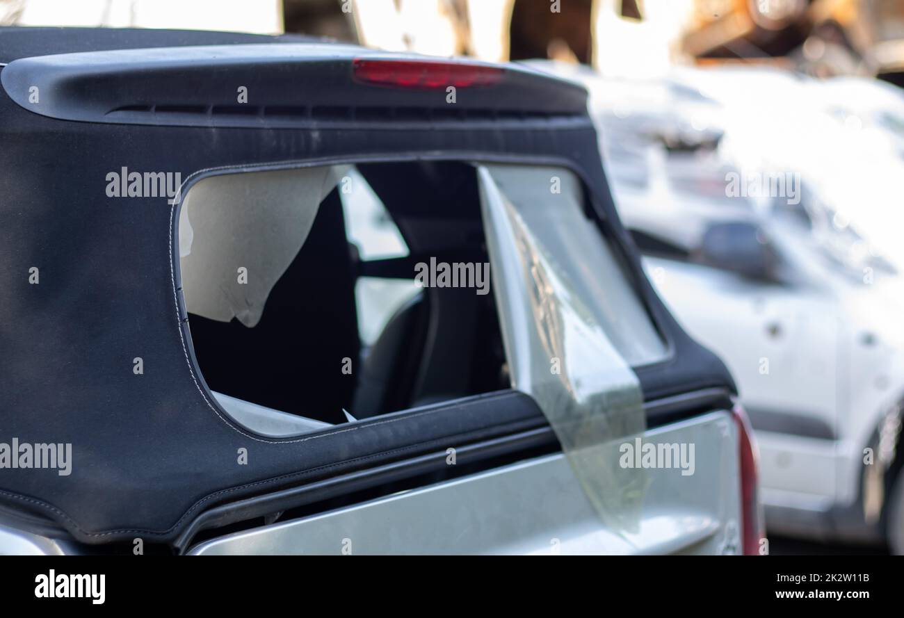 Beschädigtes Dachmaterial an der Rückseite des Cabriolets. Vandalismus, Diebe haben das Dach eines Cabrios von hinten durchgeschnitten. Diebstahl von Sachen aus dem Auto. Krimineller Zwischenfall. Autoeinbruch. Stockfoto