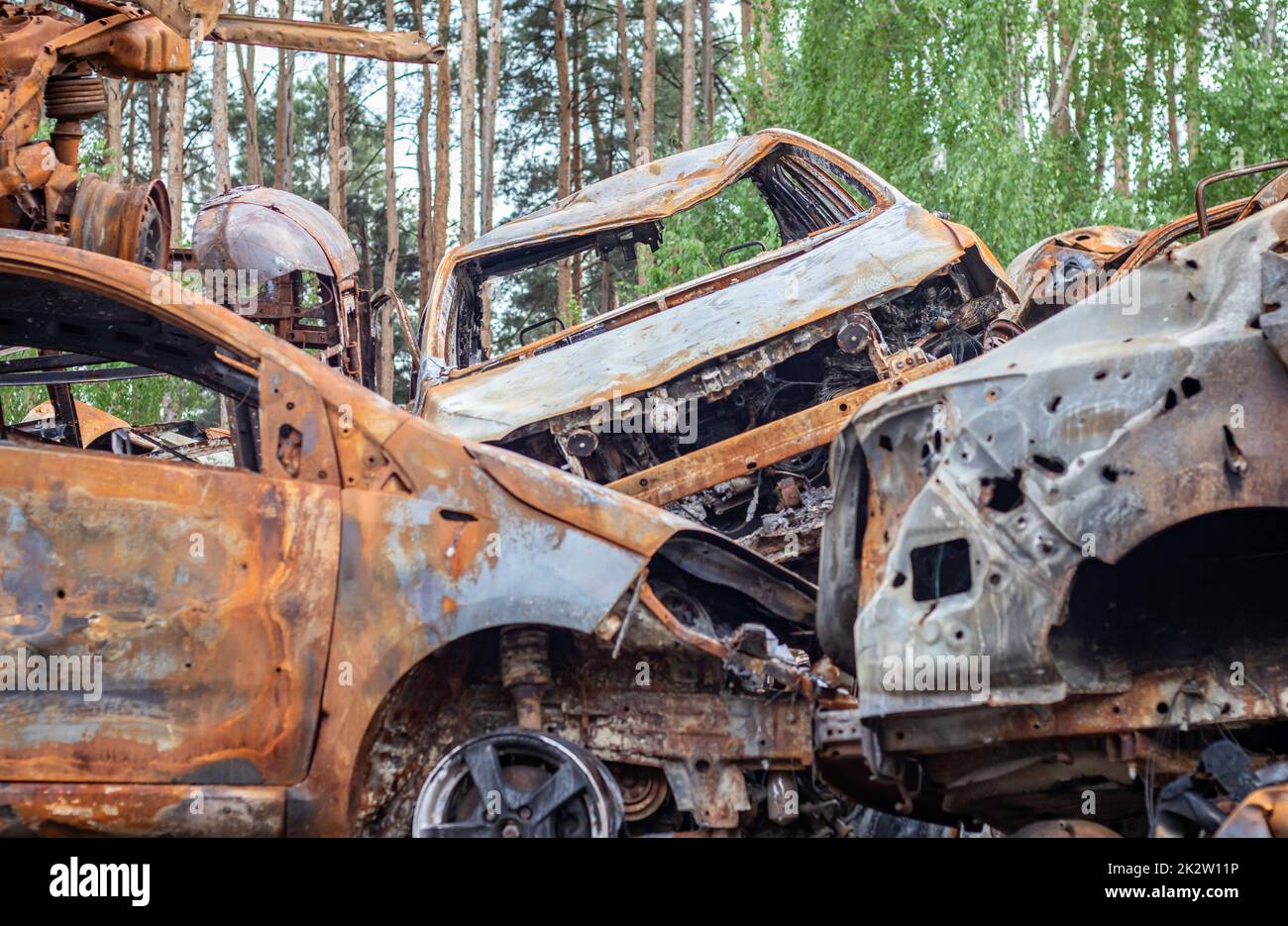 Ein Blick auf abgebrannte Autos nach Raketenangriffen des russischen Militärs. Krieg Russlands gegen die Ukraine. Ziviles Fahrzeug nach dem Brand. Friedhof der Autos in der Stadt Irpin. Rostiger Haufen Metall. Stockfoto