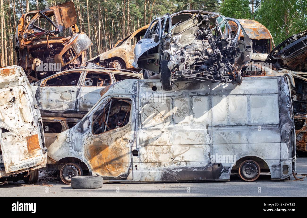 Autos nach dem Feuer. Eisenteile eines verbrannten Autos. Ausgebrannte Autos, die auf einer ruhigen Landschaft stehen. Explosion, die Folge eines Brandes. Kfz-Versicherungskonzept. Krieg Russlands gegen die Ukraine. Stockfoto