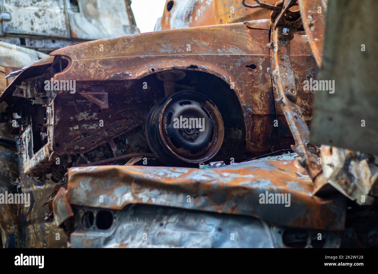 Kaputte und verbrannte Autos auf dem Parkplatz, Unfall oder vorsätzlicher Vandalismus. Verbranntes Auto. Folgen eines Autounfalls. Durch Brandstiftung beschädigt. Mülldeponie ziviler Fahrzeuge, die von russischen Truppen in der Ukraine erschossen wurden. Stockfoto