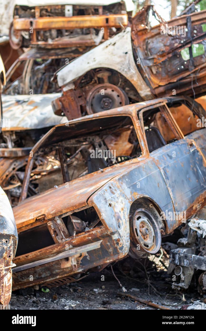 Viele rostige, verbrannte Autos in Irpen, nachdem sie vom russischen Militär erschossen wurden. Russlands Krieg gegen die Ukraine. Friedhof mit zerstörten Autos von Zivilisten, die versuchten, das Kriegsgebiet zu verlassen. Stockfoto