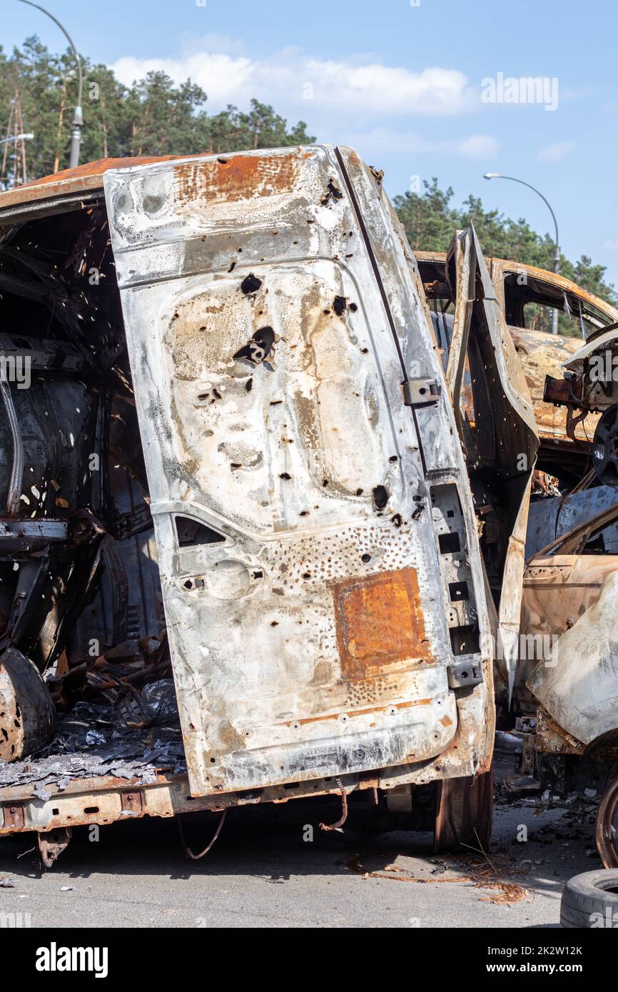 Autos nach dem Feuer. Eisenteile eines verbrannten Autos. Ausgebrannte Autos, die auf einer ruhigen Landschaft stehen. Explosion, die Folge eines Brandes. Kfz-Versicherungskonzept. Krieg Russlands gegen die Ukraine. Stockfoto