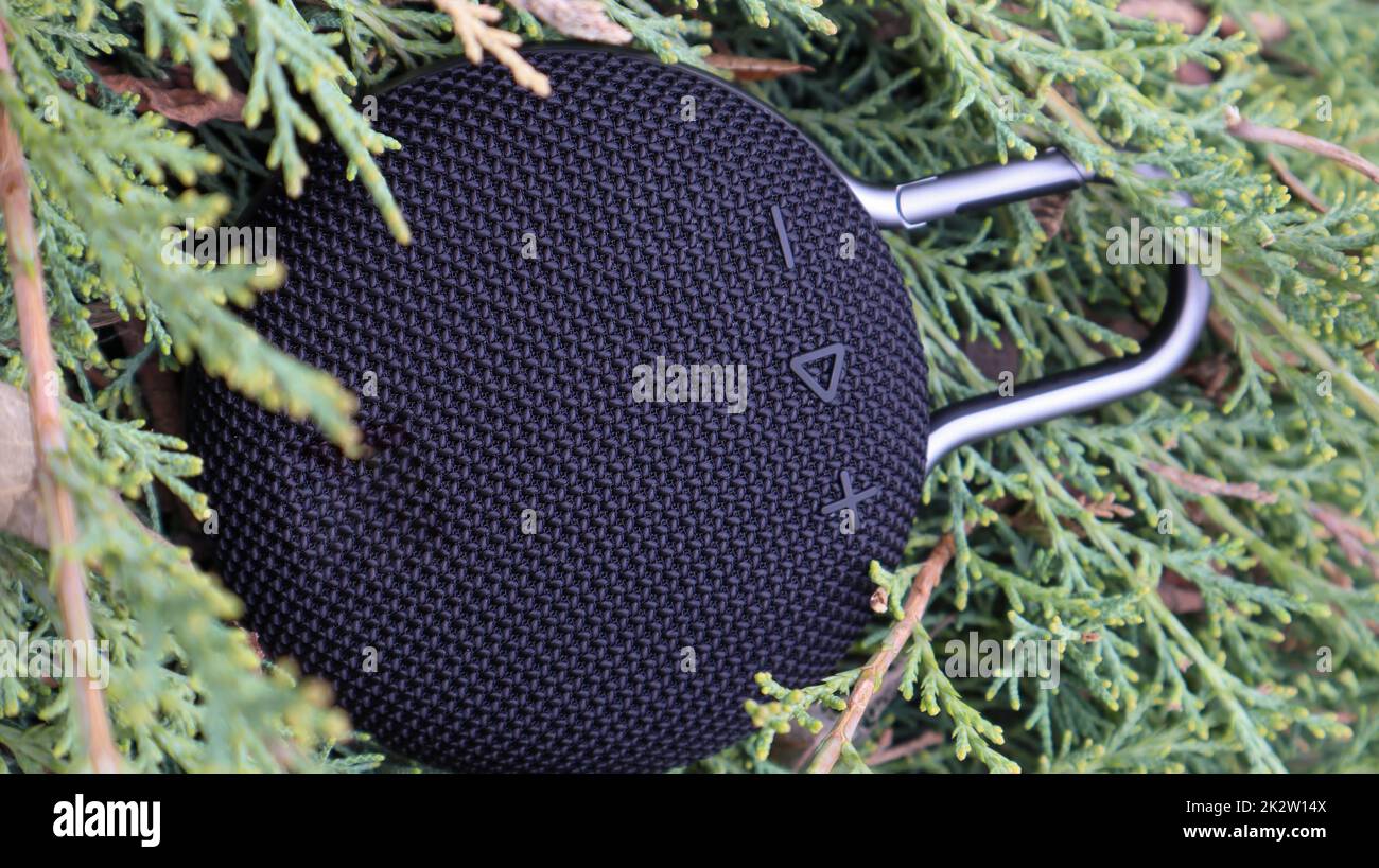 Wasserdichter runder Bluetooth-Lautsprecher mit Karabiner in Schwarz. Digitales Musik- und Audiokonzept. Mini, für Reisen geeignet. Stockfoto