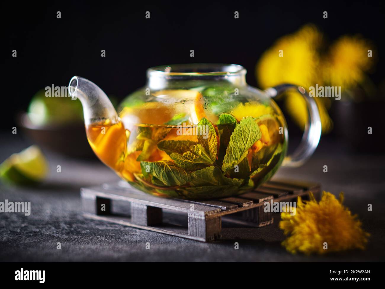 Glasteekanne mit Fruchtkrautee. Zusammensetzung der Werbung: Tee mit Orange, Minze, Sanddorn und Kräutern Stockfoto