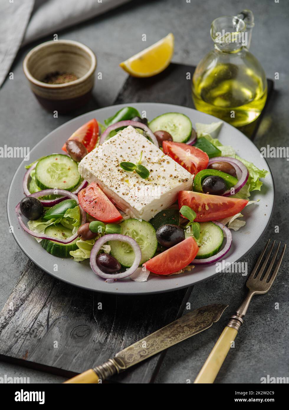 Griechischer Salat mit frischer Gurke, Tomaten, Paprika, Salat, roten Zwiebeln, Feta-Käse und Oliven mit Olivenöl. Stockfoto