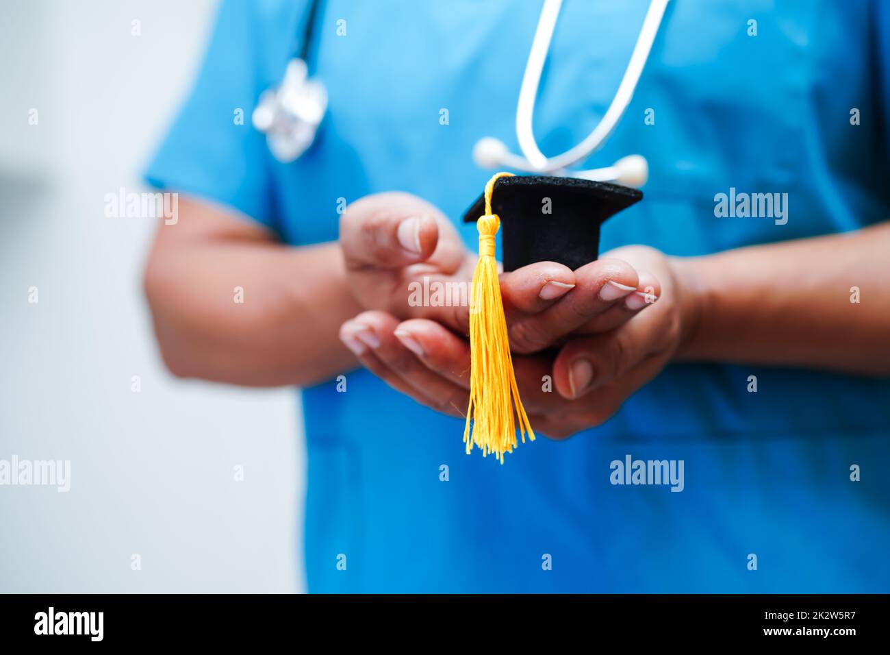 Asiatische Frau Arzt hält Abschlusshut im Krankenhaus, Medizinische Ausbildung Konzept. Stockfoto