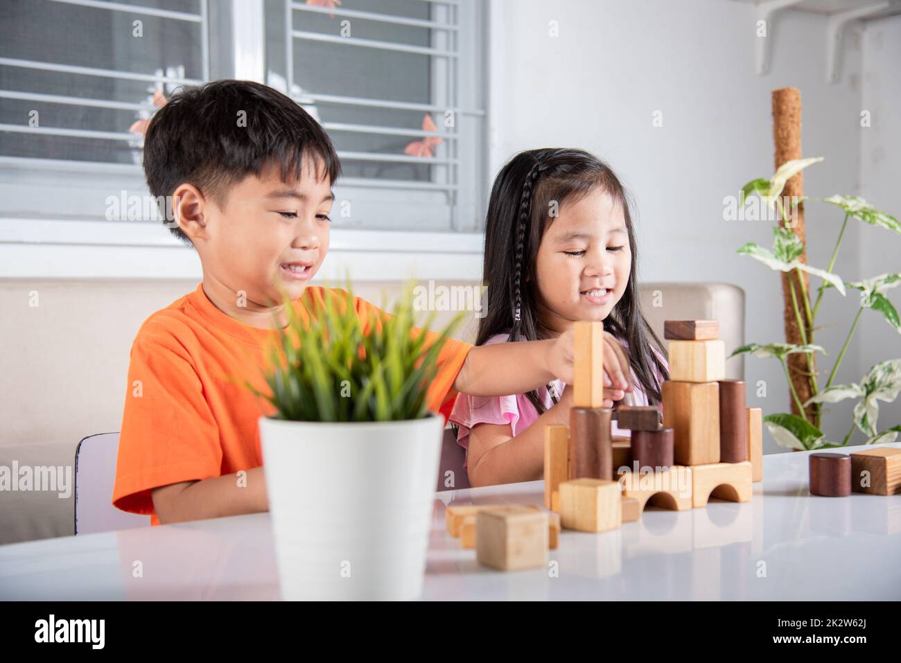 Kinder Junge und Mädchen spielen mit Bauunternehmer Holzblock Gebäude Stockfoto