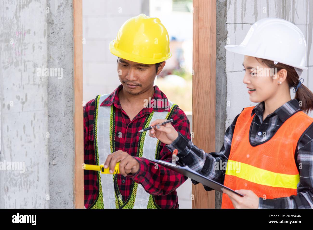 Männliche industrielle Bauarbeiter Verlegeprozess Holztür mit Maßband messen Stockfoto