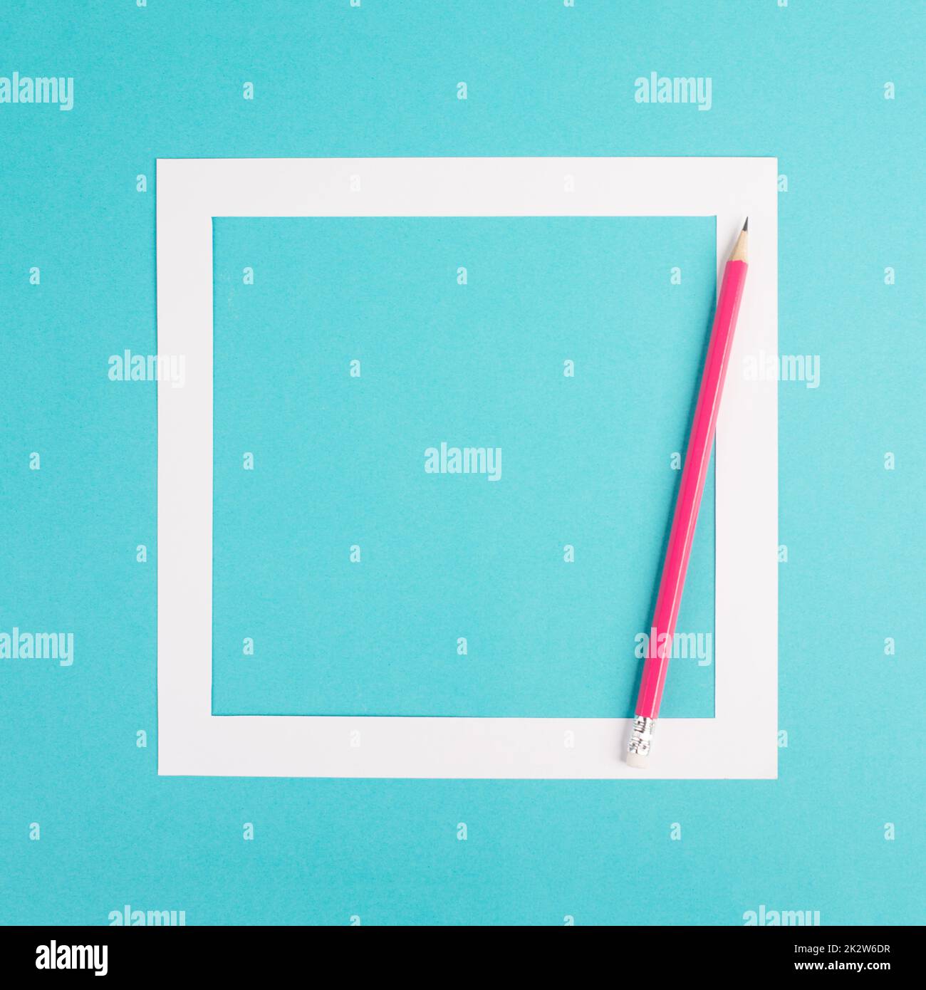 Bleistifte auf blauem Papierhintergrund, weißer Rahmen mit Platz für Text, Minimalismus, kreatives und geschäftliches Konzept, pastellfarben Stockfoto