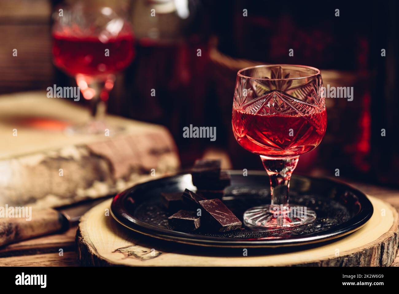 Ein Glas roter Likör mit Schokoriegeln Stockfoto