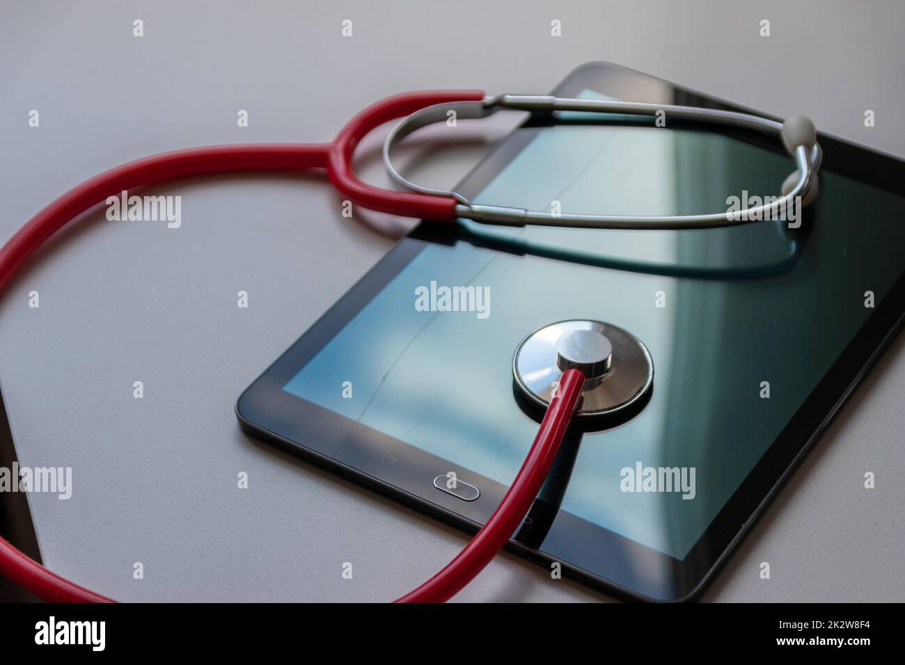 Rotes Stethoskop auf schwarzem Tablet-Gerät zeigt Gesundheitsdaten und digitale Patientendatensätze auf Cloud-Datensicherheit für digitale Ärzte und digitale Wiederherstellungsdiagnosen mit modernen Geräten und Technologien Stockfoto