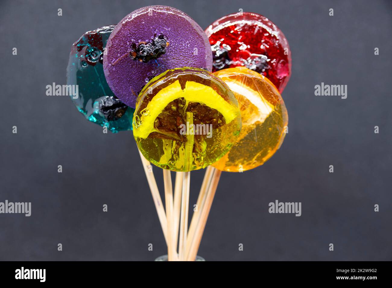Farbige Lollipops machen Nahaufnahmen auf grauem Hintergrund Stockfoto