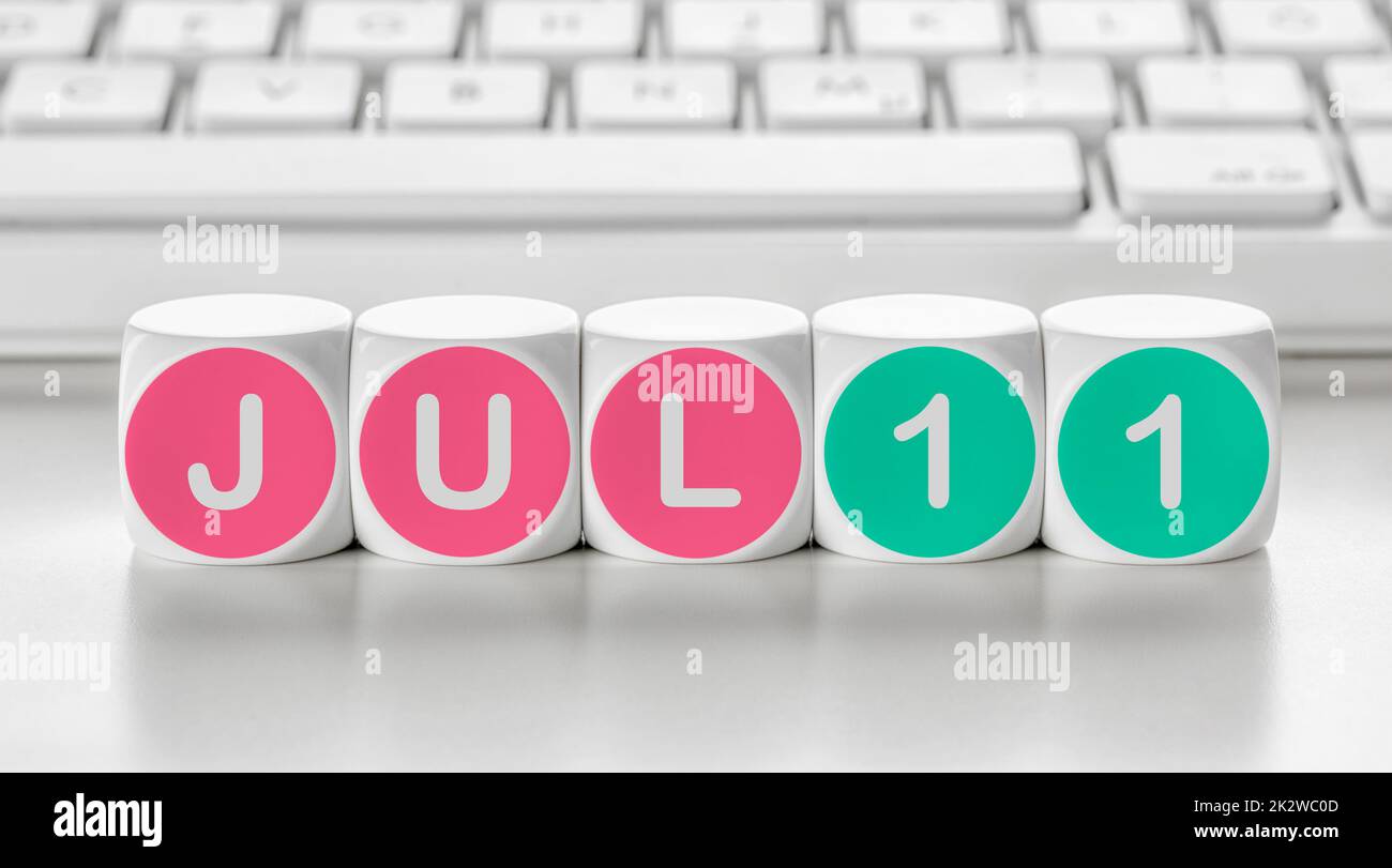 Buchstabenwürfel vor einer Tastatur - 11. Juli Stockfoto