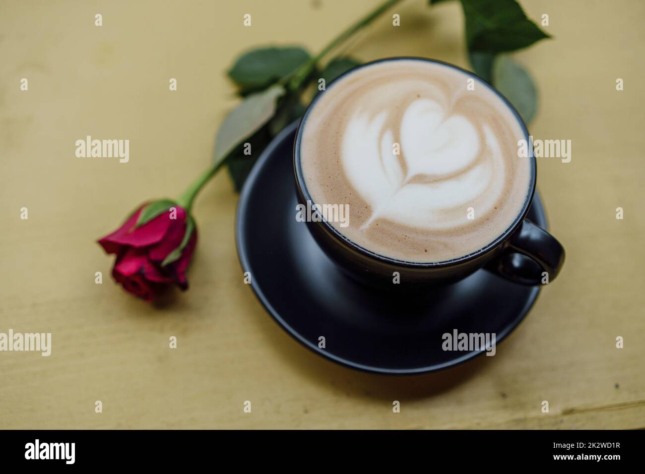 Cappuccino mit Latte Art und einer roten Rose Stockfoto