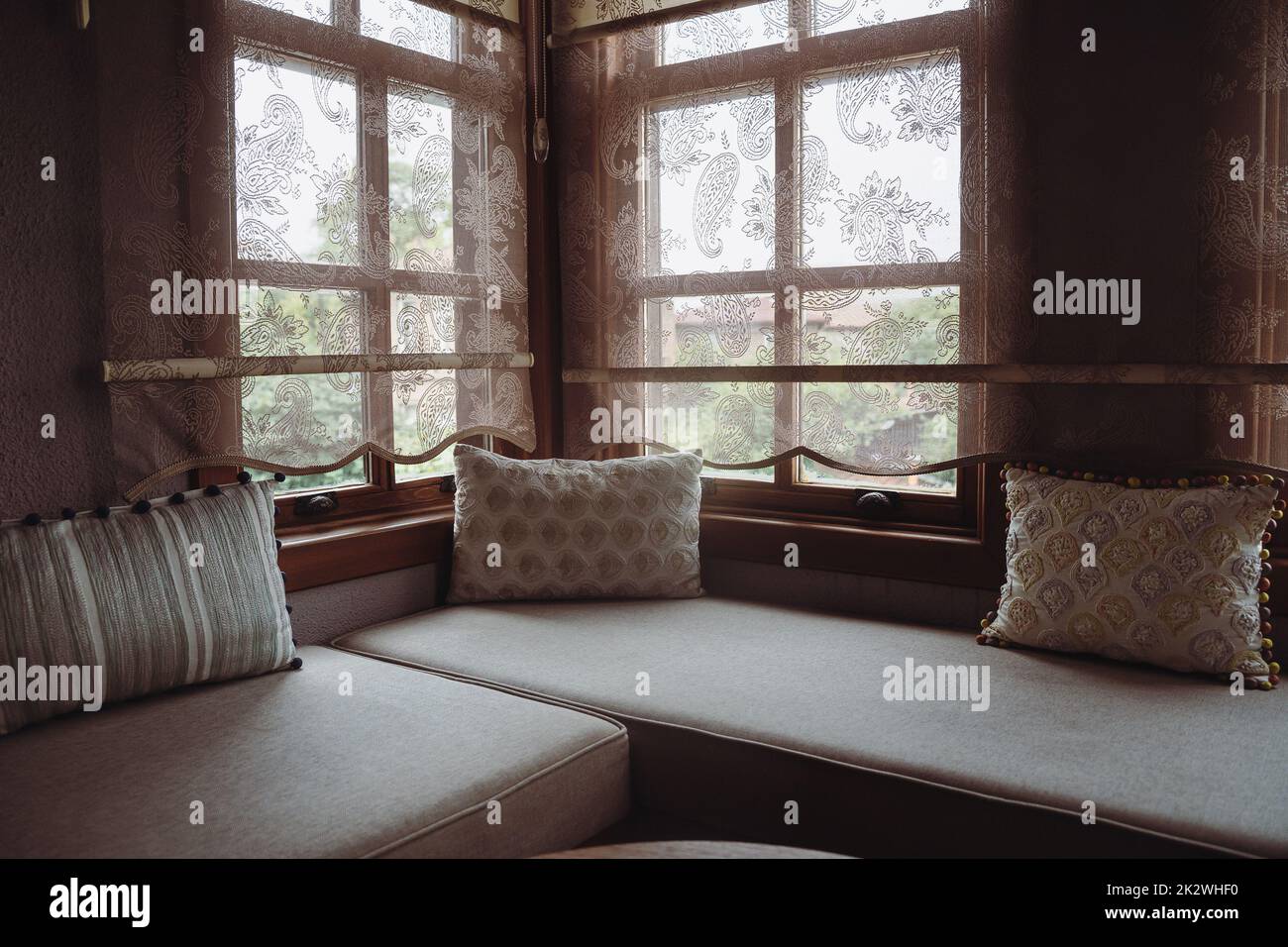 Vorderansicht des Divan mit mehreren Kissen vor dem Fenster Stockfoto