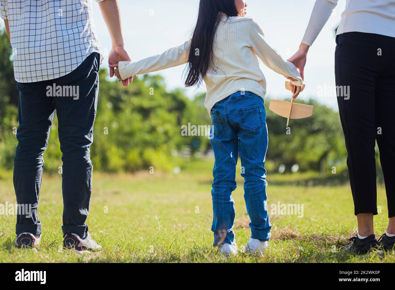Asiatische Familie, die Spaß hat und gemeinsam im Park die Straße entlang spazieren geht Stockfoto