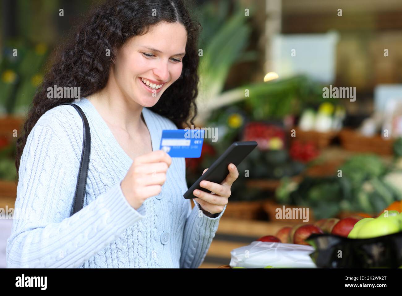 Glückliche Frau, die online in einem Gemüsehändler einkauft Stockfoto