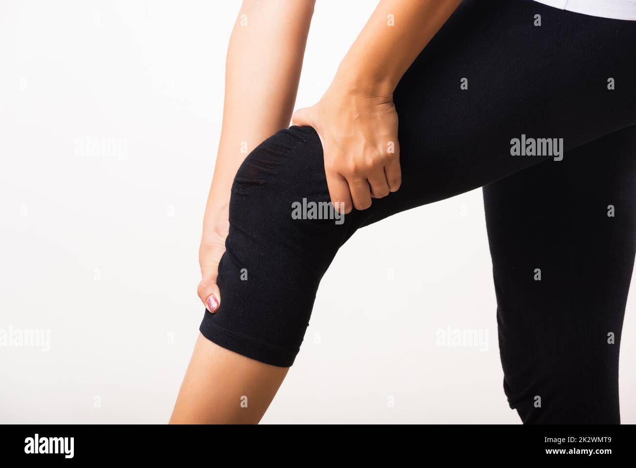 Frau Schmerzen Knie und sie verwendet Handgelenk halten Knie Qual Stockfoto