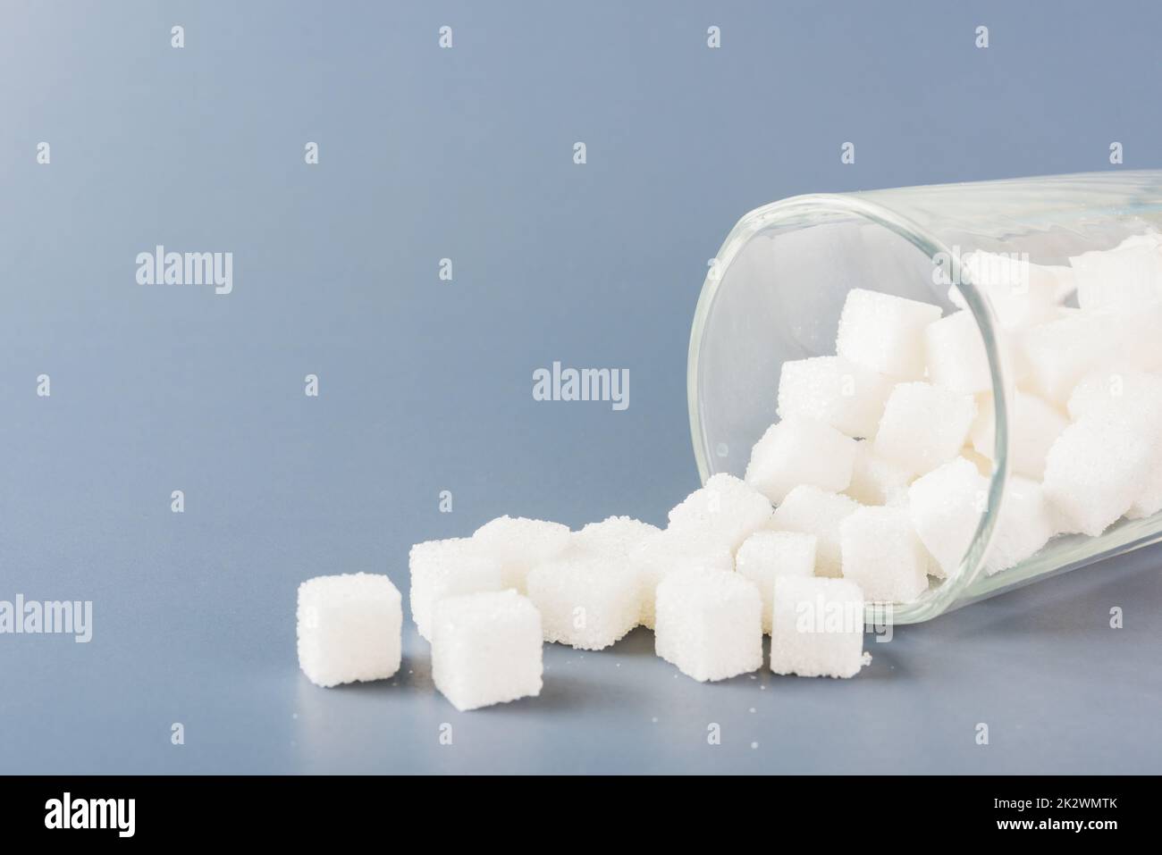 Zuckerwürfel, süße Lebensmittelzutat, die aus dem Glas geschüttet wurde Stockfoto