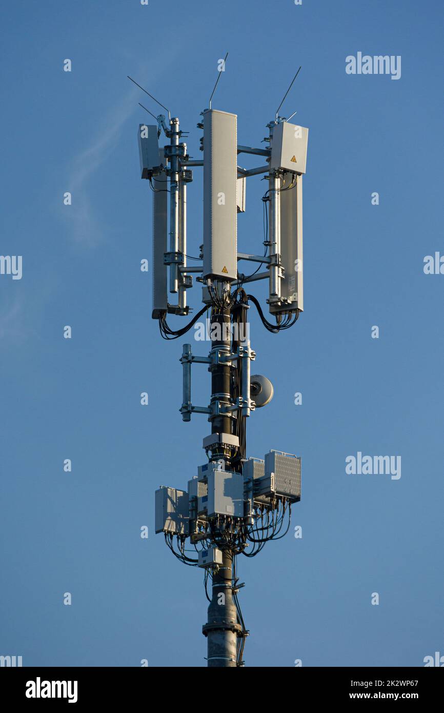 Nahaufnahme eines Antennenmastes für die Mobilfunkkommunikation vor blauem Himmel Stockfoto