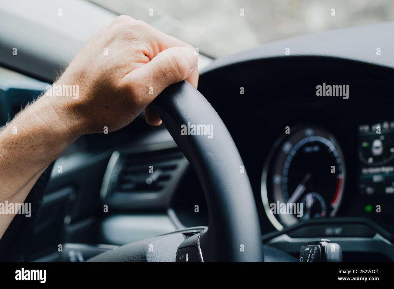 Männliche Hände am Lenkrad eines Autos Stockfoto