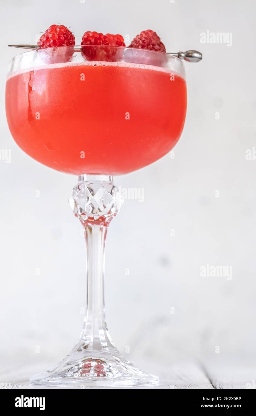 Ein Glas Blinker Cocktail garniert mit Himbeeren Stockfoto