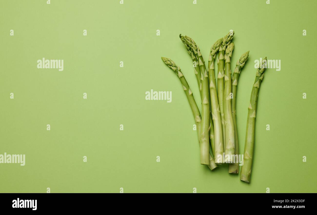 Bund frischer Spargel auf grünem Papier Hintergrund, Draufsicht Stockfoto