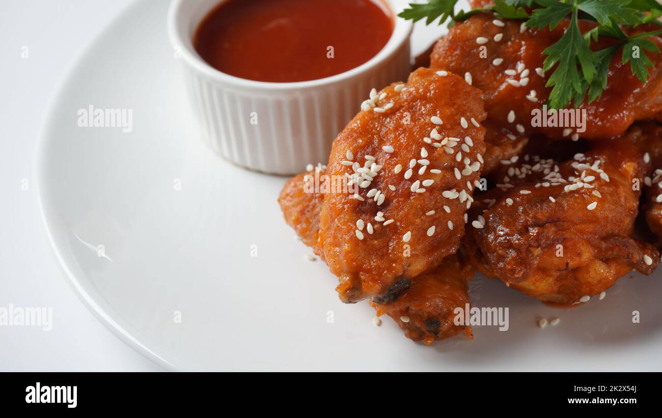 Gebratene Chicken Wings auf einem weißen Teller mit Gewürzen und Dip. Warme Fleischgerichte Stockfoto