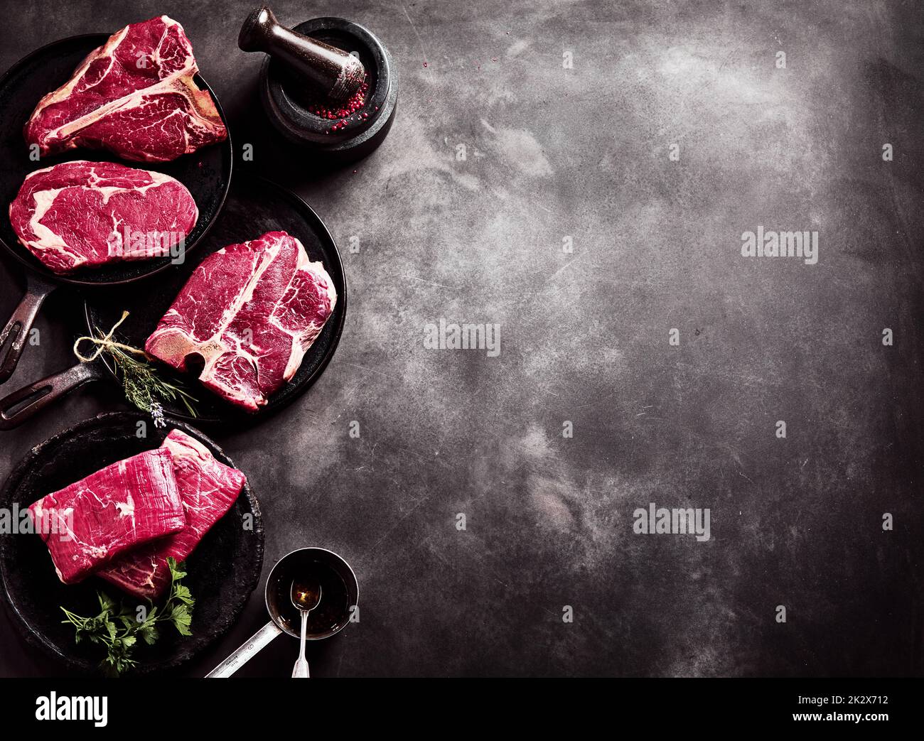 Rohes Rindfleisch auf Pfannen auf dem Tisch Stockfoto