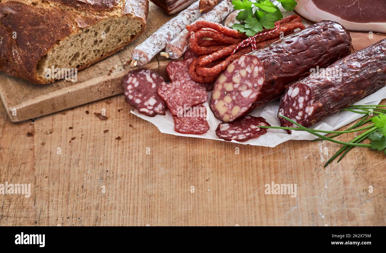 Geräucherte Würstchen in der Nähe von frischem Brot Stockfoto