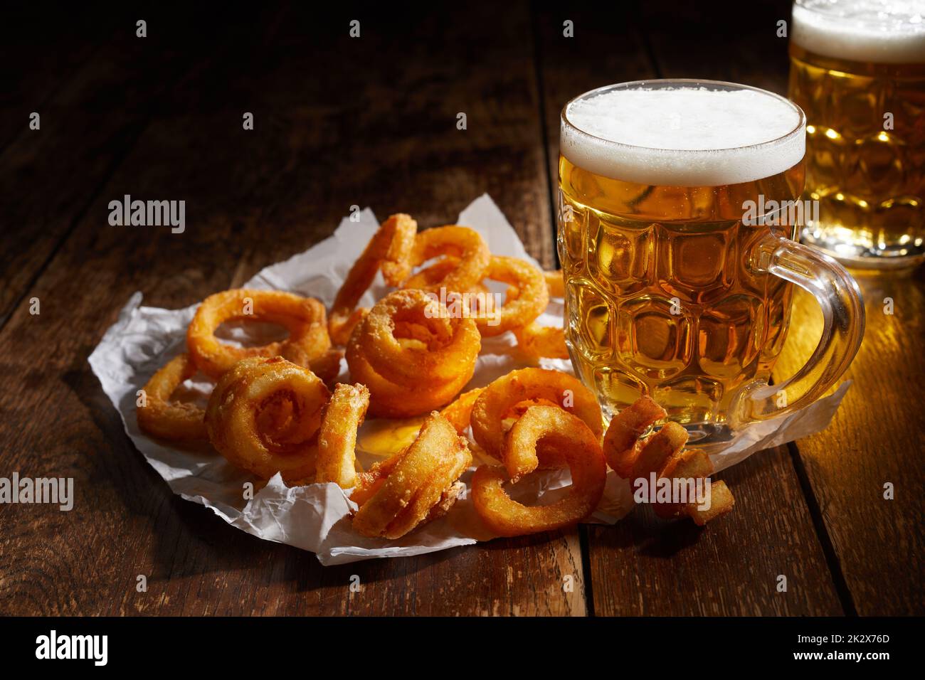 Leckere Kartoffellocken und Becher Bier Stockfoto
