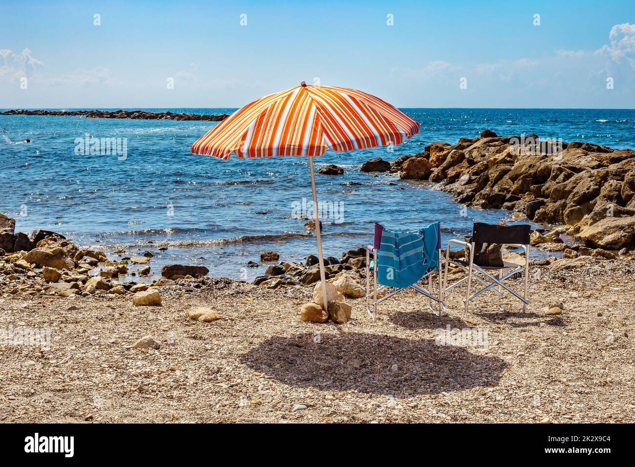 Sonnenschirm und zwei Stühle an einem Kieselstrand in Monterosso al Mare. Stockfoto