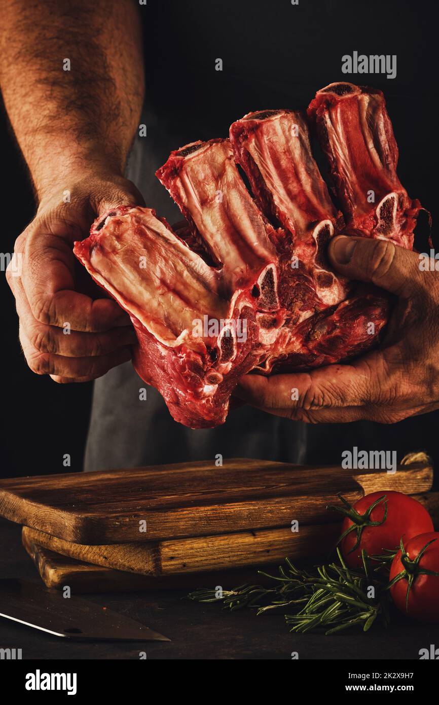 Männlicher Metzger schneidet rohes Rindfleisch. Stockfoto