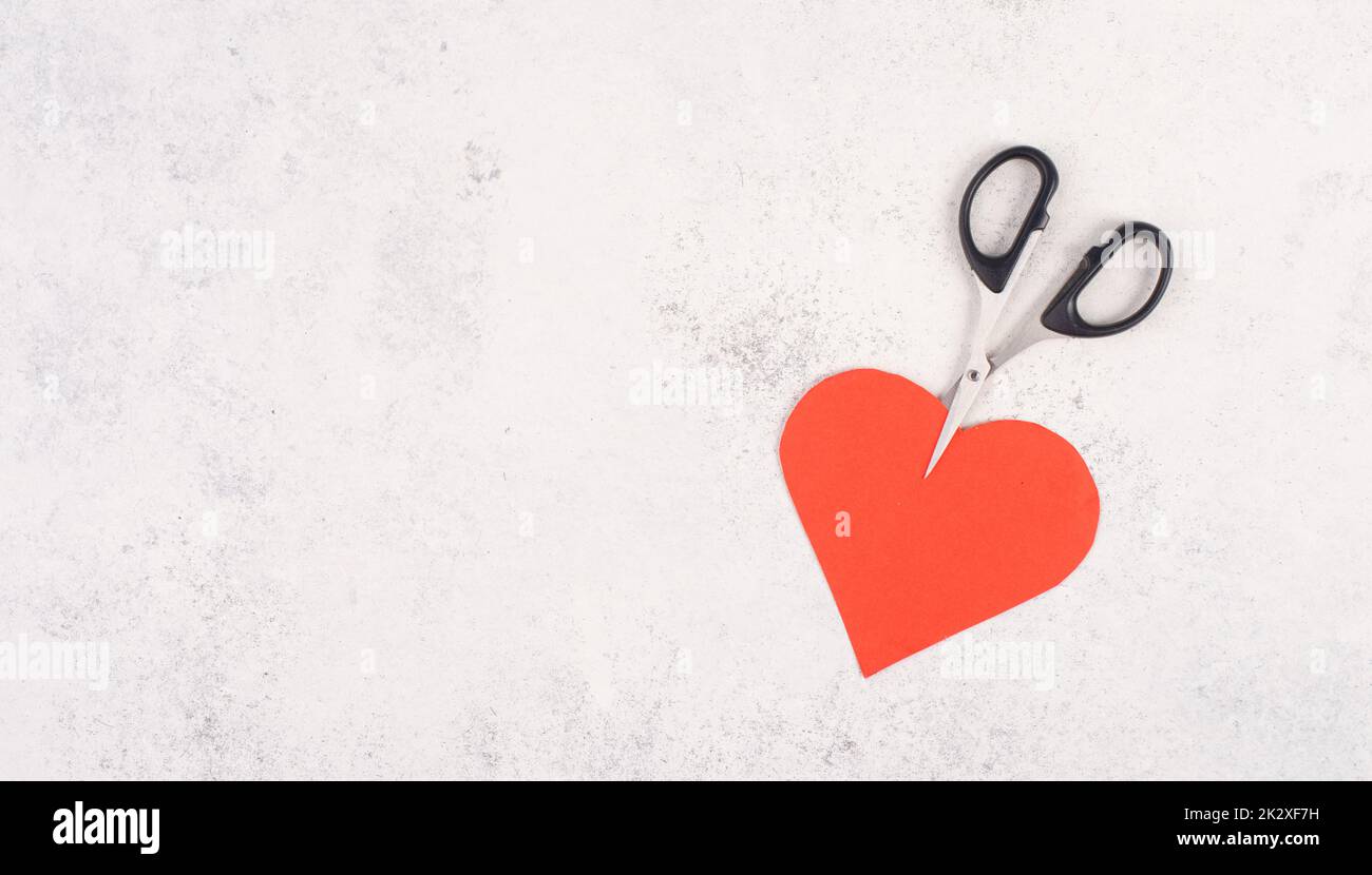 Rotes Herz von der Schere geschnitten, Symbol für gebrochene Beziehung, Liebe und Emotion Konzept, Scheidung und Auflösung Probleme Stockfoto