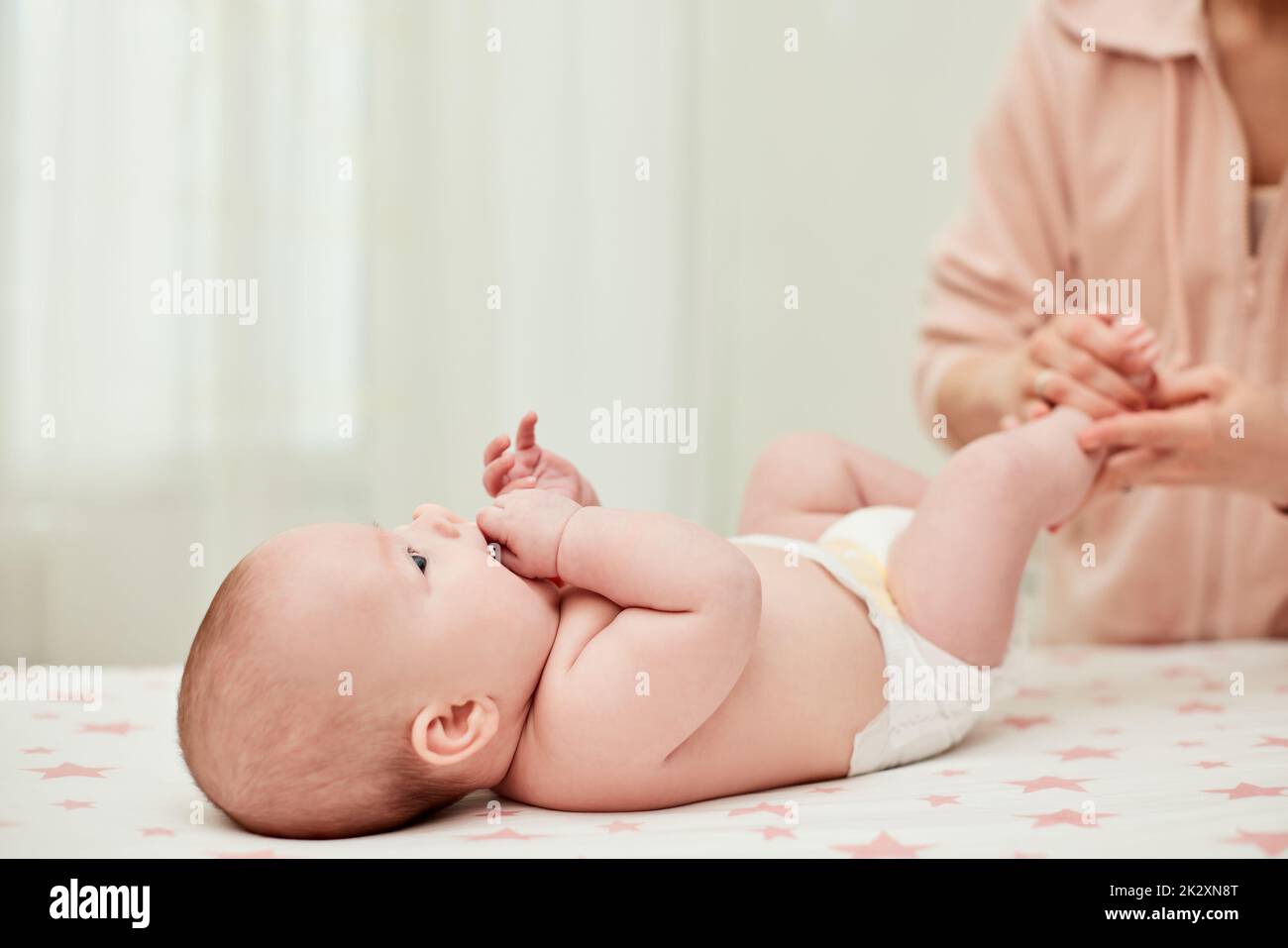 Mutter oder Therapeut, die ihr Kind zu Hause massiert Stockfoto