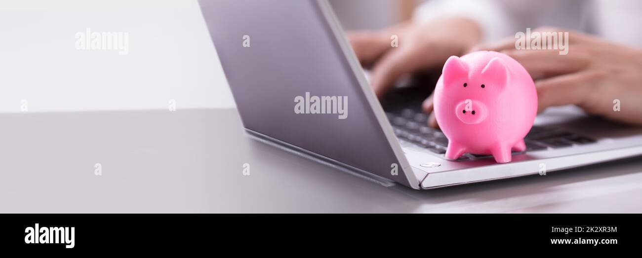 Pinkfarbenes Piggybank Auf Laptop-Tastatur Stockfoto