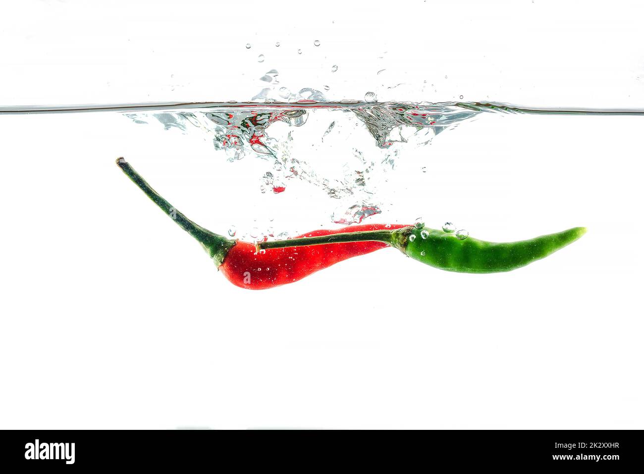 Rote Chili, Wasserspritzer, auf weißem Hintergrund gelötet Stockfoto