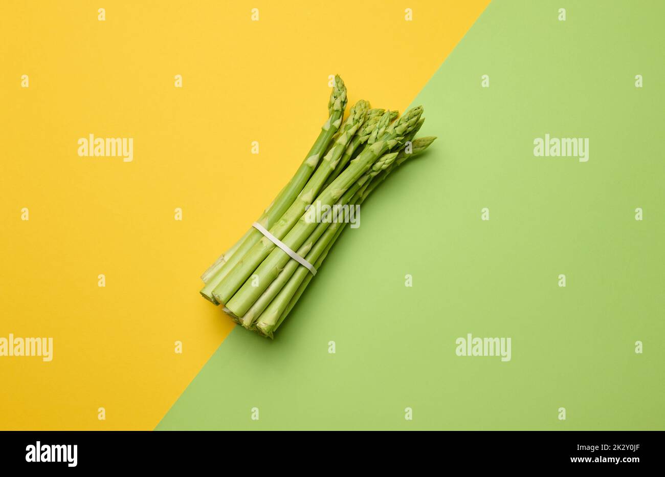 Ein paar frische Spargel auf grünem Papier Hintergrund Stockfoto