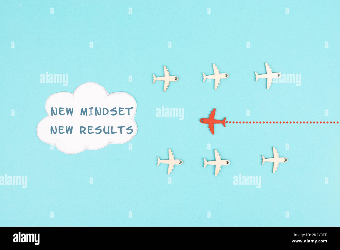 Red Airplane fliegt in die Cloud mit den Worten New Mindset New Results, Changing Lifestyle, Coaching und Improvement Concept, positive Thinking Stockfoto