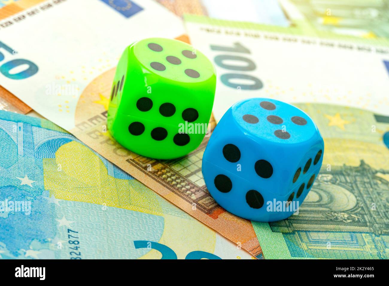 Blaue und grüne Würfel Nahaufnahme auf einem Hintergrund mit Euro-Banknoten Stockfoto