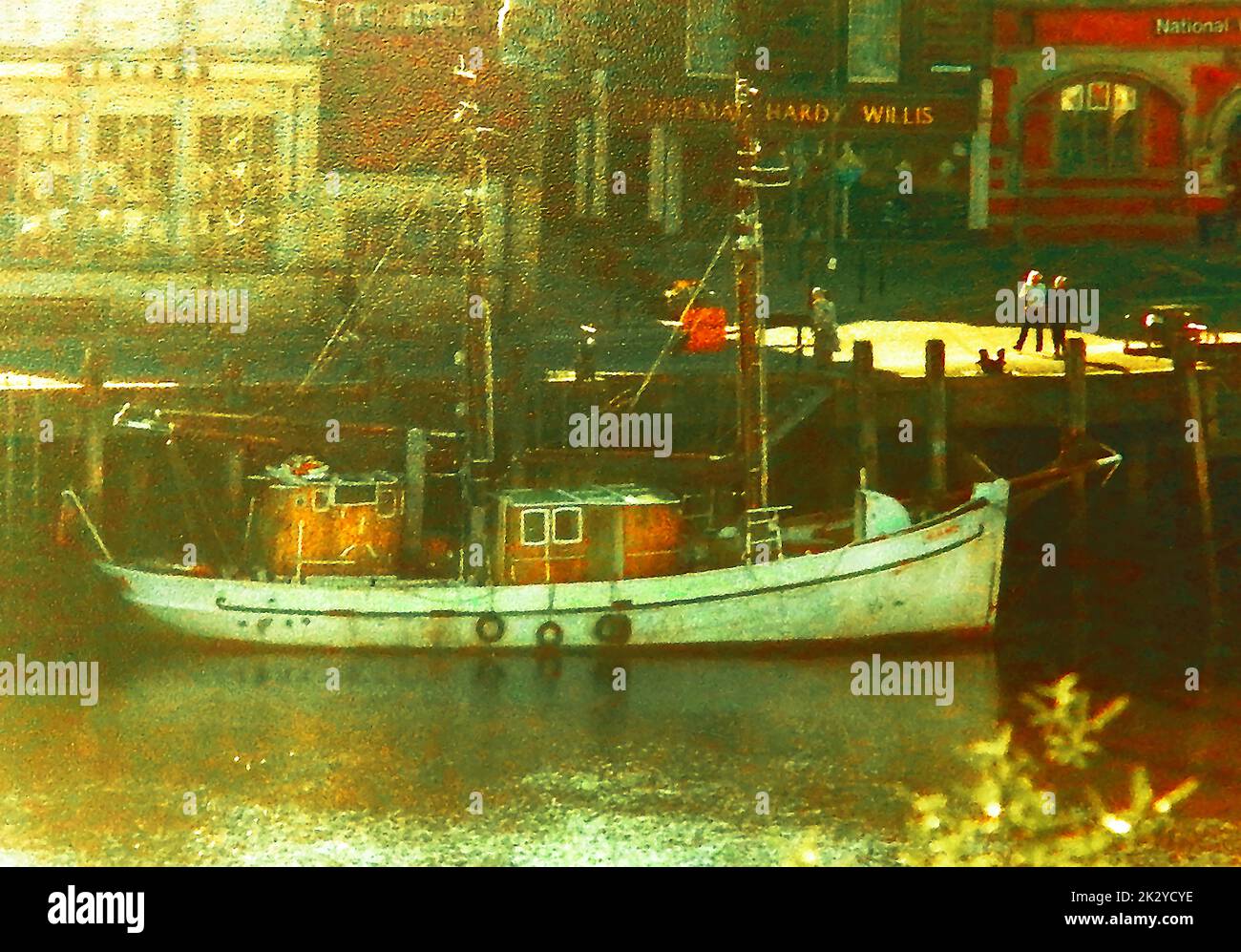 Eine seltene, farbige Momentaufnahme des Fischerbootes Helga Maria, das in der Nähe der Brücke in Whitby, North Yorkshire, Großbritannien, festgemacht ist. Die Helga Maria inspirierte den Film „Captain Jack“, nachdem „Captain Jack Lammiman sich den Seebehörden widersetzte und mit einer bunt gemischten, ungeschulten Crew in die Arktis segelte. Er tarnt sein Schiff, während der Reise, indem er es mit einer anderen Farbe malte als die, die von den Seebehörden und Küstenwachen gesucht wird. Stockfoto