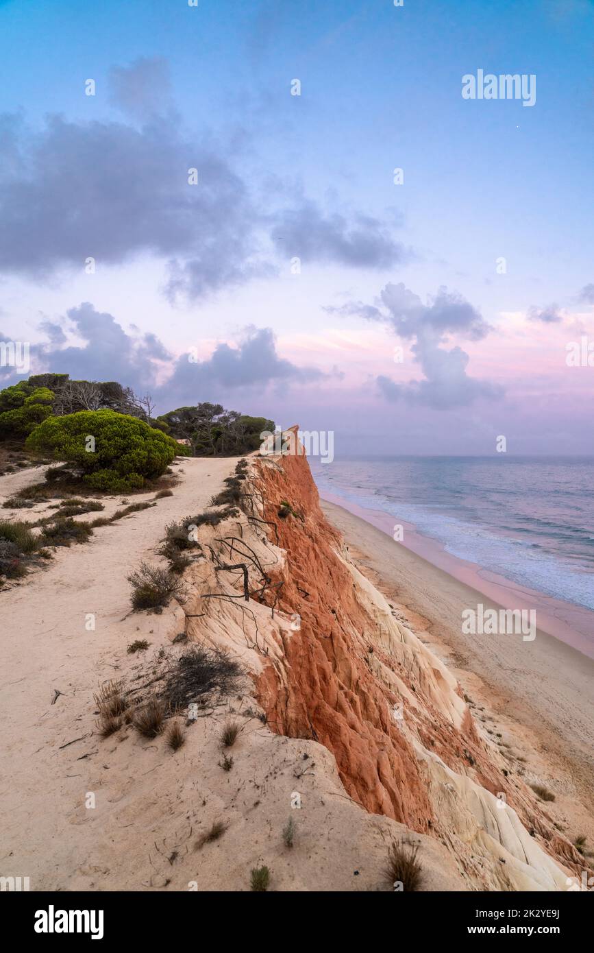 Sonnenuntergang über der wunderschönen Landschaft in Praia de Falesia, Algarve Region, Portugal. Wunderschöne Himmelsfarben spiegeln sich im Meerwasser wider Stockfoto