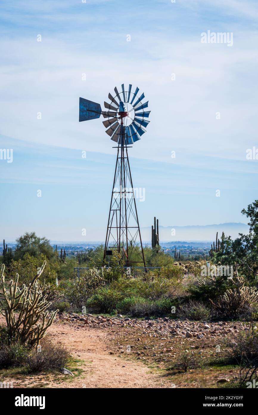 Feuerverzinkte Windmühle und Wüstenlandschaft im White Tank Mountain Regional Park in Waddell, Arizona. Stockfoto