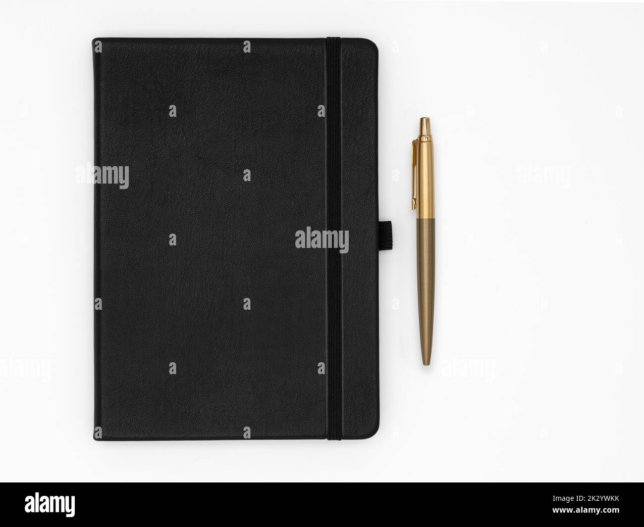 Schwarzes Notizbuch geschlossen und goldener Stift daneben auf weißem Hintergrund Stockfoto