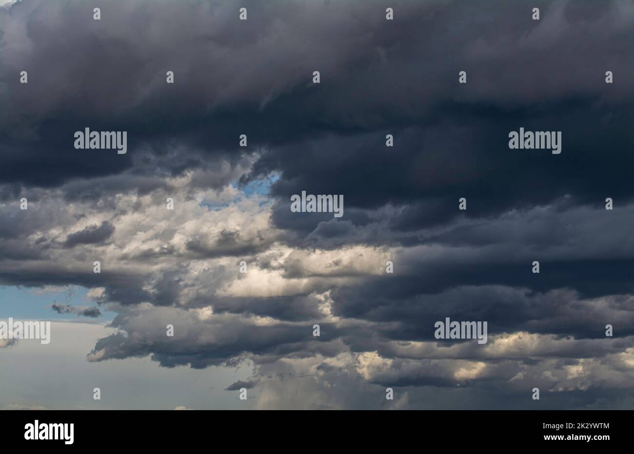 Dicke dunkle Wolken am blauen Himmel Stockfoto